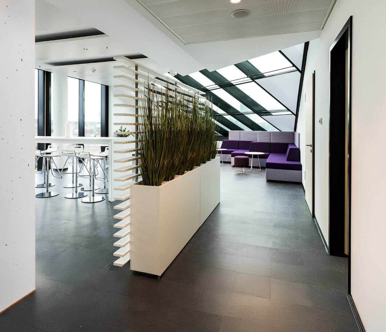 Modernes Büro mit Lounge-Bereich und Stehtischen – offene Arbeitsumgebung für B2B-Meetings, Workshops und Zusammenarbeit.